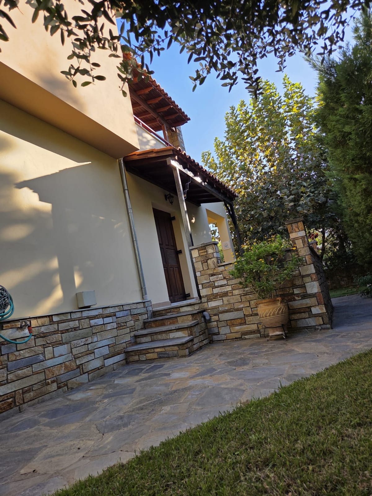 Front entrance with stone cladding and wooden door